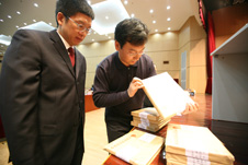 中國質量檢驗協會秘書長助理張明(左一)、企業工作部副主任趙劍波(左二)在復賽考場現場啟封試卷